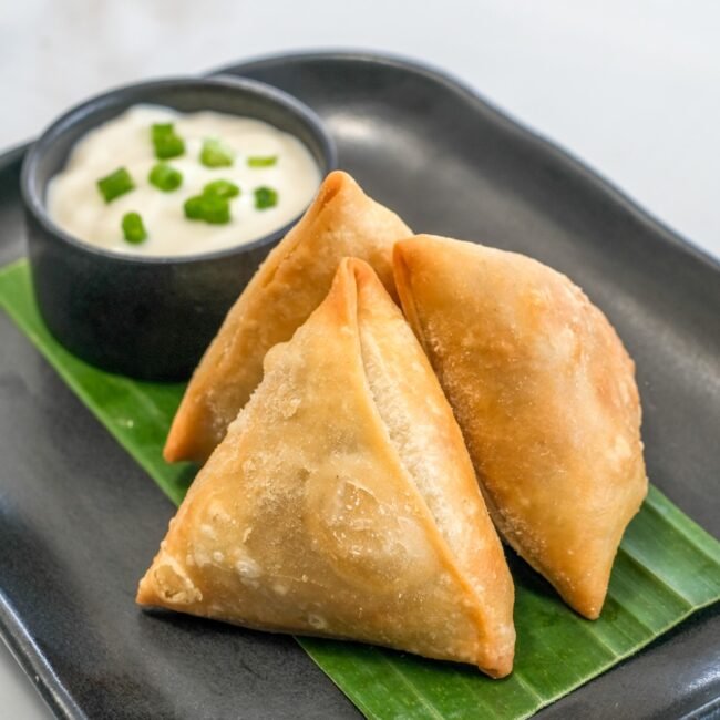 Sauce Tree's crispy plant-based samosa filled with veggies and served with sour cream dipping sauce